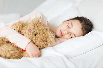 Image showing girl sleeping with teddy bear toy in bed at home