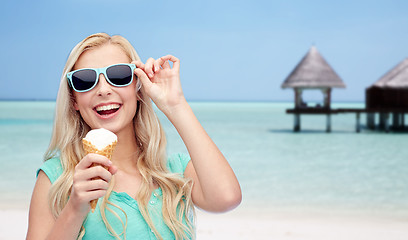 Image showing happy woman in sunglasses with ice cream on beach
