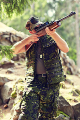 Image showing soldier or hunter shooting with gun in forest