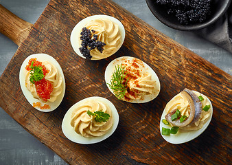 Image showing boiled decorative stuffed eggs on wooden cutting board