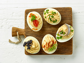 Image showing boiled decorative eggs on wooden cutting board