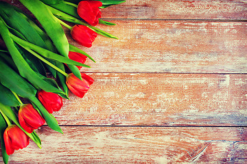 Image showing close up of red tulips on wooden background