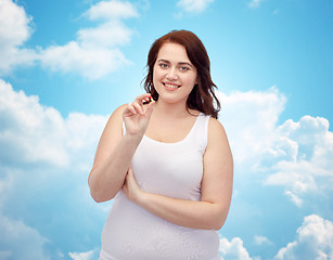 Image showing happy plus size woman in underwear with pill