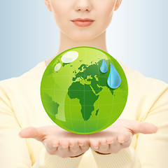 Image showing close up of woman holding green globe in her hands