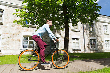 Image showing happy young hipster man riding fixed gear bike