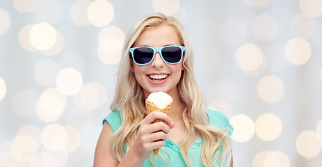 Image showing happy young woman in sunglasses eating ice cream