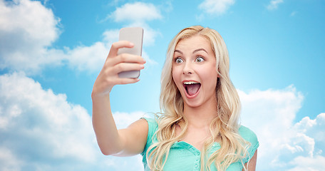 Image showing smiling young woman taking selfie with smartphone