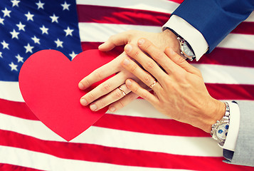 Image showing close up of male gay couple hands with red heart