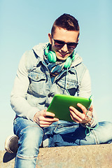 Image showing happy young man with tablet pc and headphones