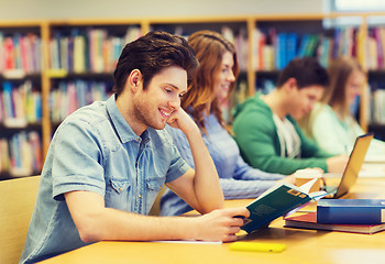 Image showing happy student boy reading books in library