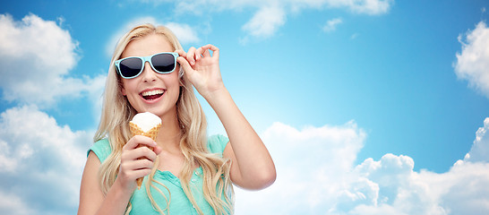 Image showing happy young woman in sunglasses eating ice cream