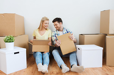 Image showing smiling couple with many boxes moving to new home