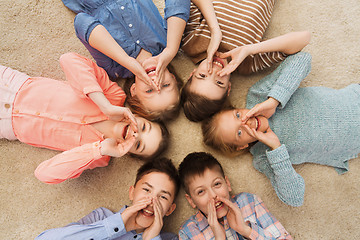 Image showing happy smiling children lying on floor in circle