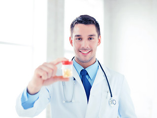 Image showing male doctor with jar of capsules