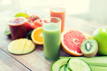 Image showing close up of fresh juice glass and fruits on table