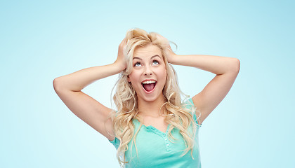 Image showing smiling young woman holding to her head or hair