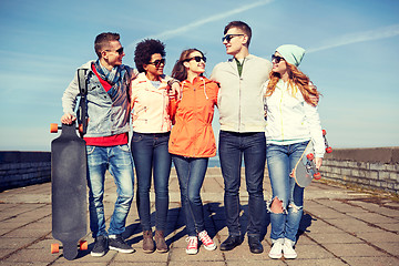 Image showing happy teenage friends with longboards on street