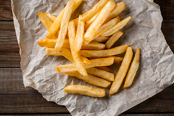 Image showing French fries on wooden table.