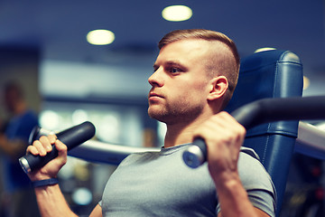 Image showing man exercising and flexing muscles on gym machine