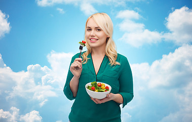 Image showing smiling young woman eating vegetable salad