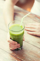 Image showing close up of woman hands with green juice