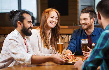 Image showing friends eating pizza with beer at restaurant