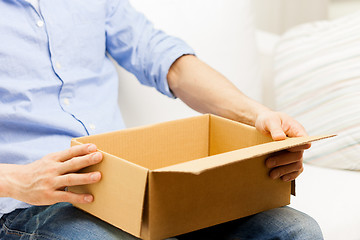 Image showing close up of man with cardboard box parcel at home