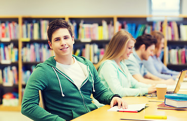 Image showing happy student boy reading books in library