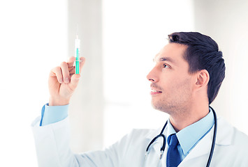 Image showing male doctor holding syringe with injection