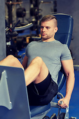 Image showing man flexing leg muscles on gym machine