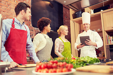 Image showing happy friends with tablet pc in kitchen