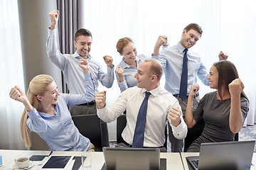 Image showing business people celebrating victory in office