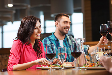 Image showing friends clinking glasses of wine at restaurant