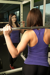 Image showing Woman doing shoulder exercise with weight bar