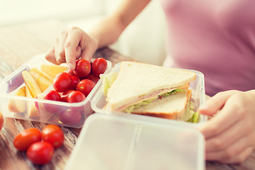 Image showing close up of woman with food in plastic container