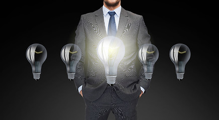 Image showing close up of businessman in suit with ligh bulbs