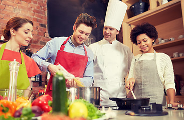 Image showing happy friends and chef cook cooking in kitchen