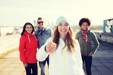 Image showing happy friends pointing finger to you on street