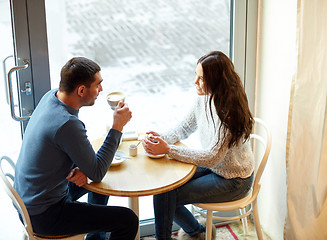 Image showing happy couple drinking tea and coffee at cafe