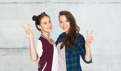 Image showing happy teenage girls hugging and showing peace sign