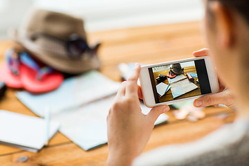 Image showing close up of woman with smartphone and travel stuff