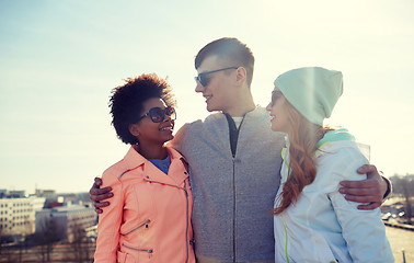 Image showing happy teenage friends in shades talking on street