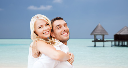 Image showing happy couple having fun over beach with bungalow