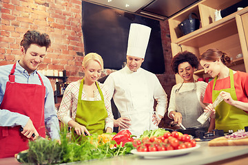 Image showing happy friends and chef cook cooking in kitchen