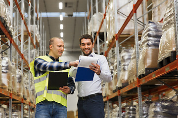 Image showing worker and businessmen with clipboard at warehouse