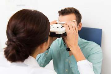 Image showing optician with pupillometer and patient at clinic