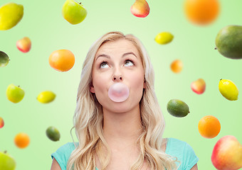 Image showing happy young woman or teenage girl chewing gum