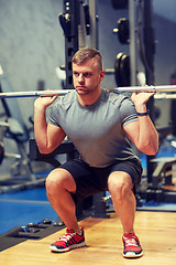 Image showing young man flexing muscles with barbell in gym