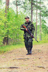 Image showing young soldier or hunter with gun in forest