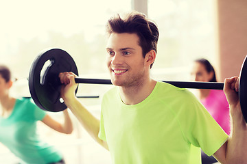 Image showing group of people exercising with barbell in gym